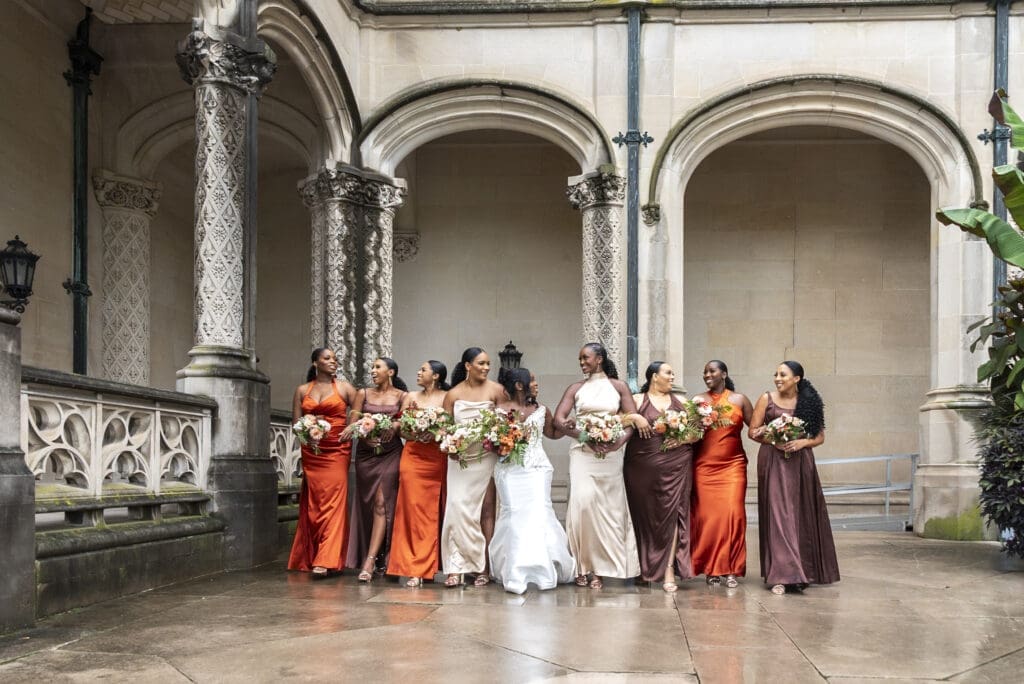 wide view Brides and bridesmaids walking surrounded by Biltmore Estate architecture 