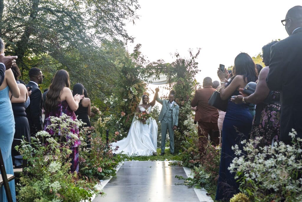 Bride and groom hands up celebration after first kiss at Diana Venue 
