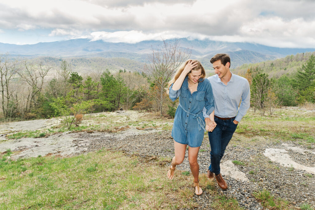 wide image of couple smiling and talking and they walked at the top of a mountain