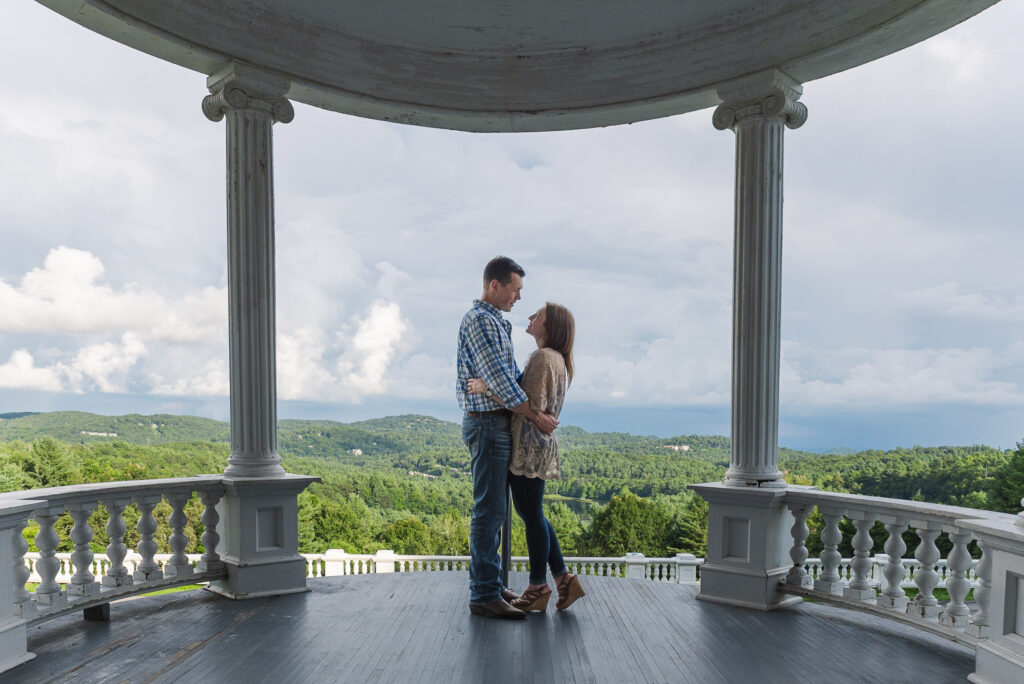 couple standing on the porch of Moses H. Cone Memorial Park with mountains in background