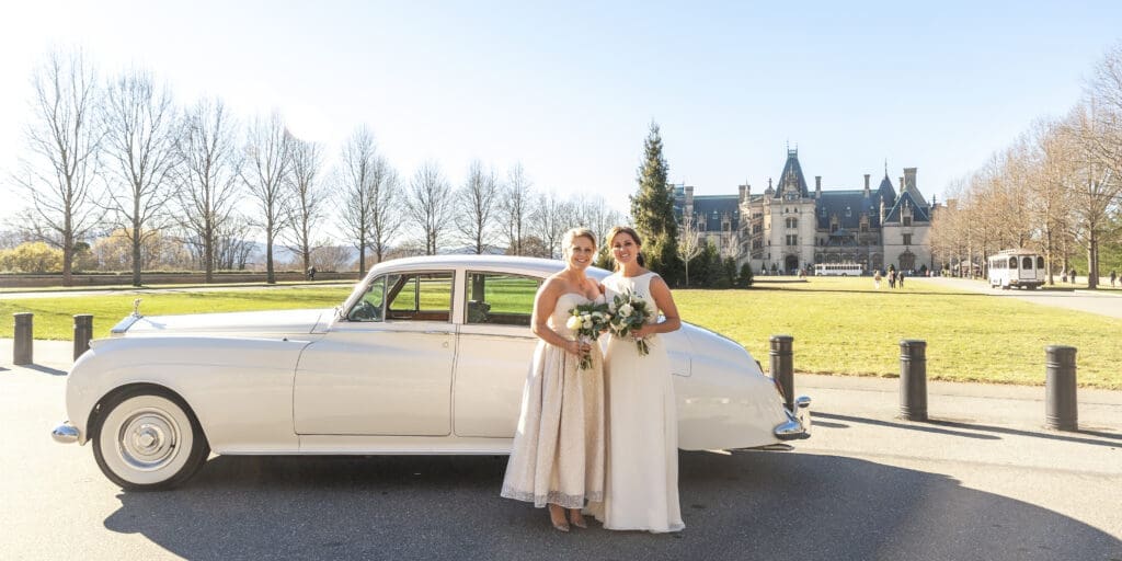 Brides standing by vintage rolls-royce on the front lawn of Biltmore Estate