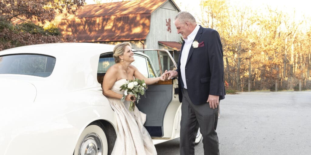dad helping bride get out of vintage Rolls-Royce