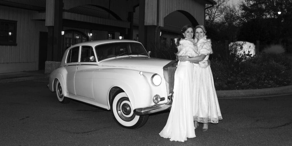 Brides standing by vintage rolls-royce in front of Lioncrest venue
