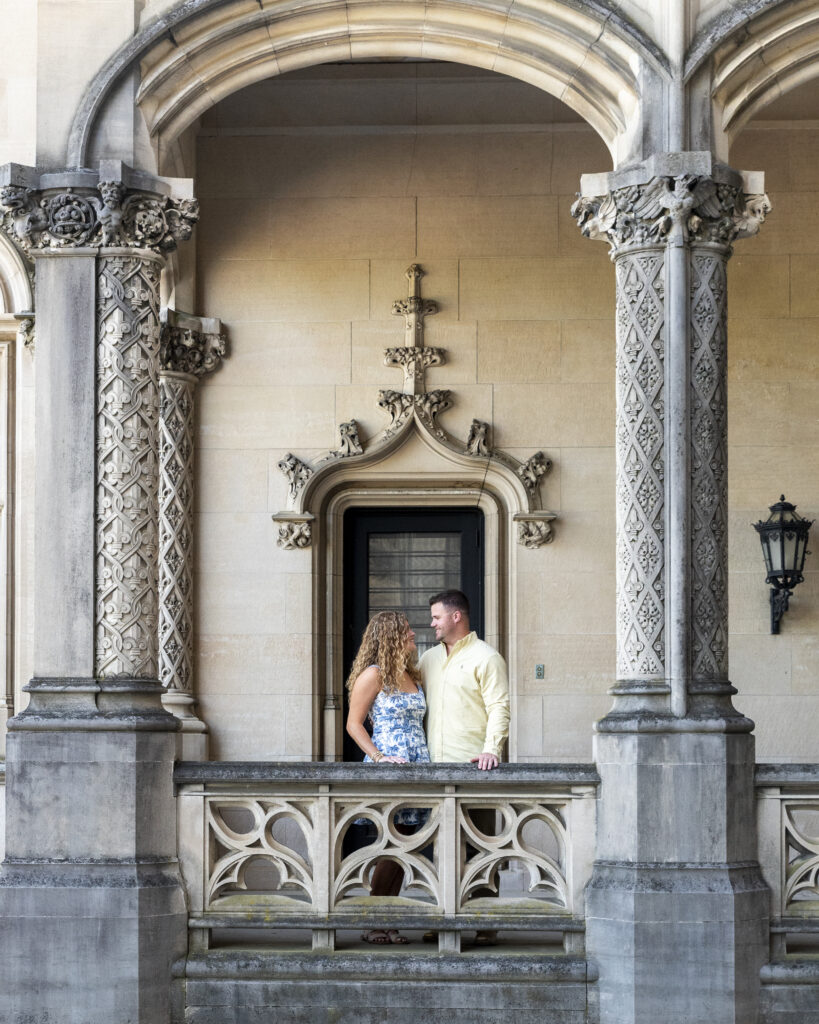 newly engaged couple standing and looking at each other surrounded by Biltmore Estate Architecture