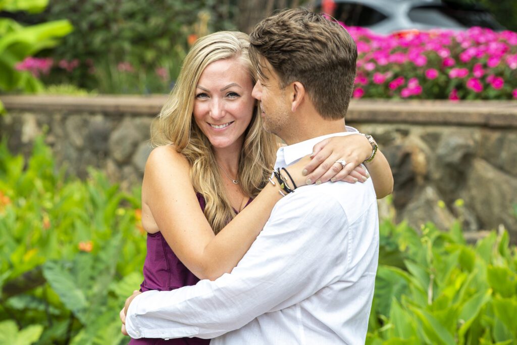 newly engaged couple hugging. woman looking at camera, fiance looking at her