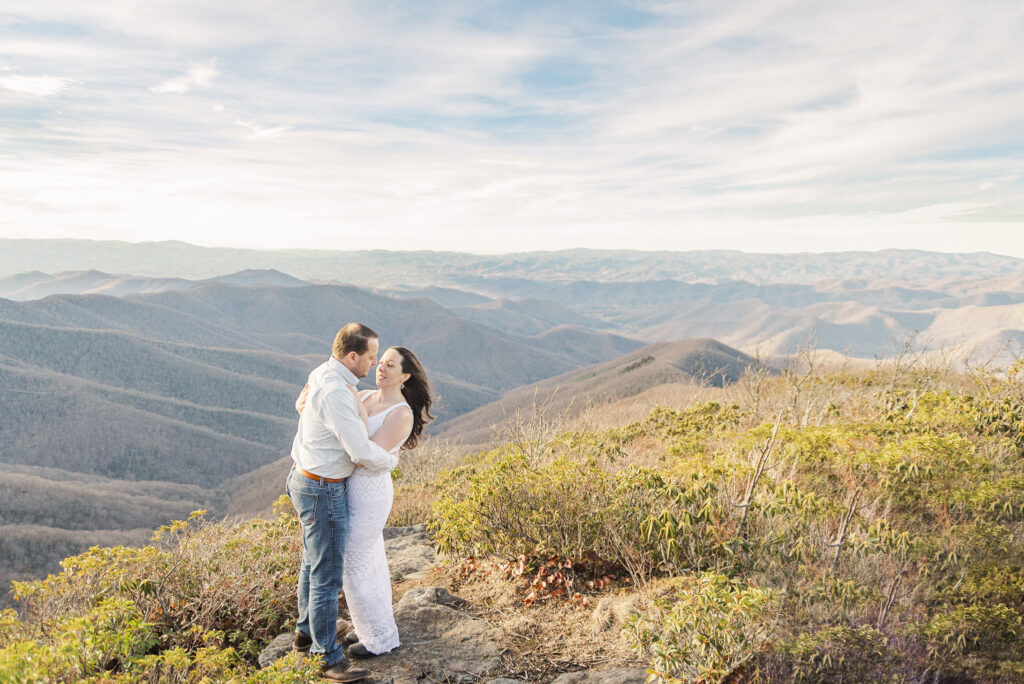 wide scenic image of engaged couple with blue ridge mountains in background