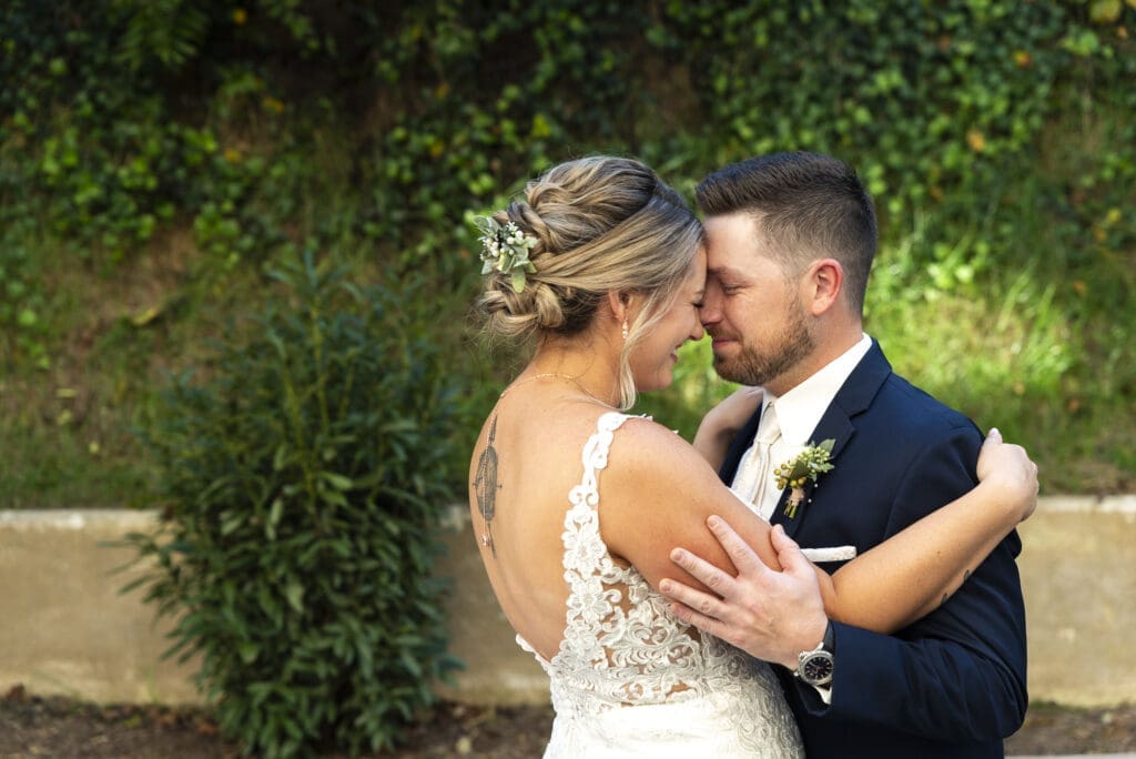 bride and groom embracing forehead to forehead during first look in asheville for crest center wedding