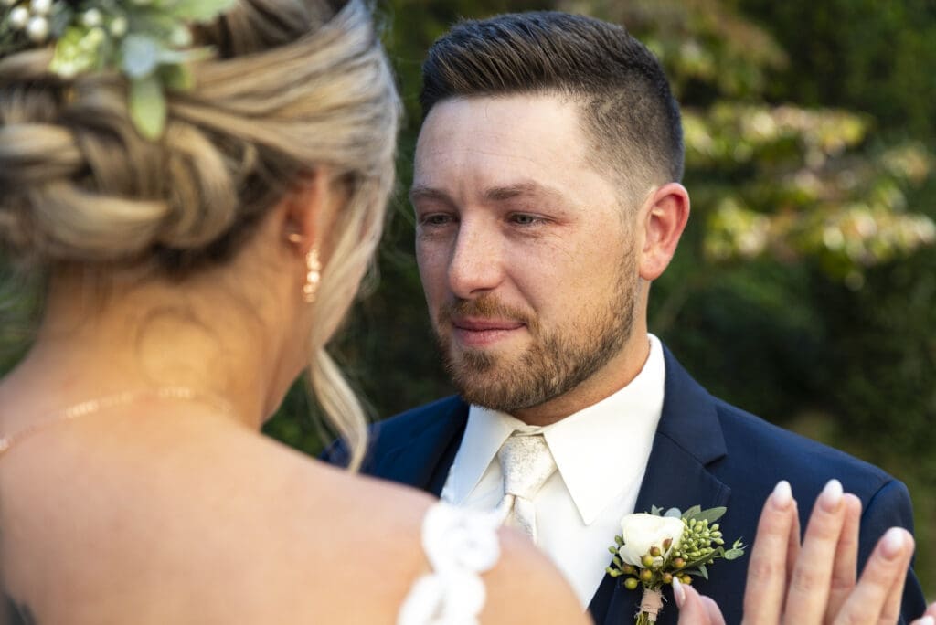 over the brides shoulder close up of grooms first reaction during first look