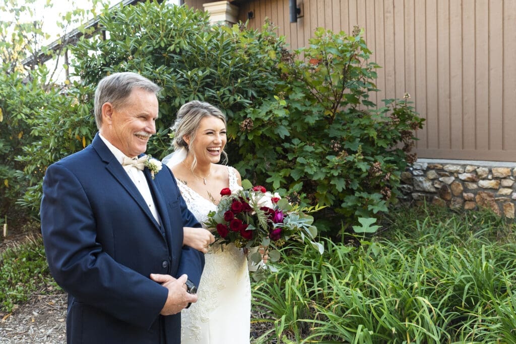 father and bride waiting to down the aisle as he gives her away during outdoor wedding ceremony with mountains in background at Crest center and pavilion