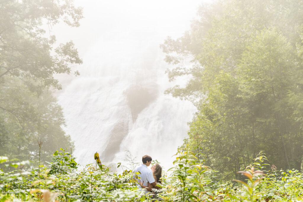 extra wide of couple on the bottom thirds of images with triple falls in the background