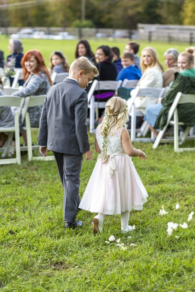 flower girl and groomsman brother walking down aisle
