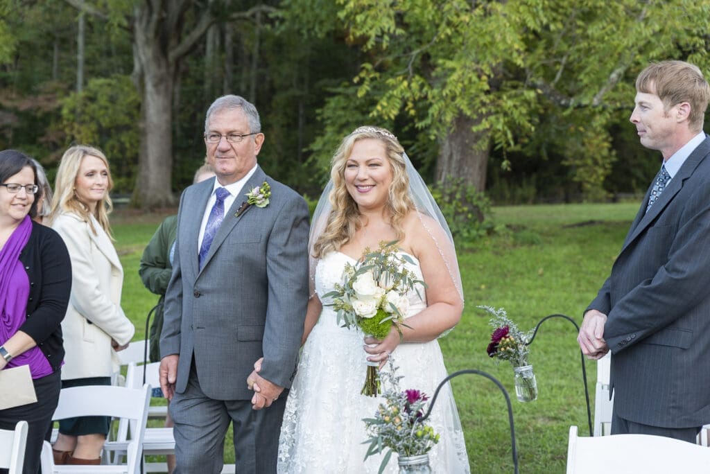 bride and father walking down aisle during ceremony at fields of blackberry cove