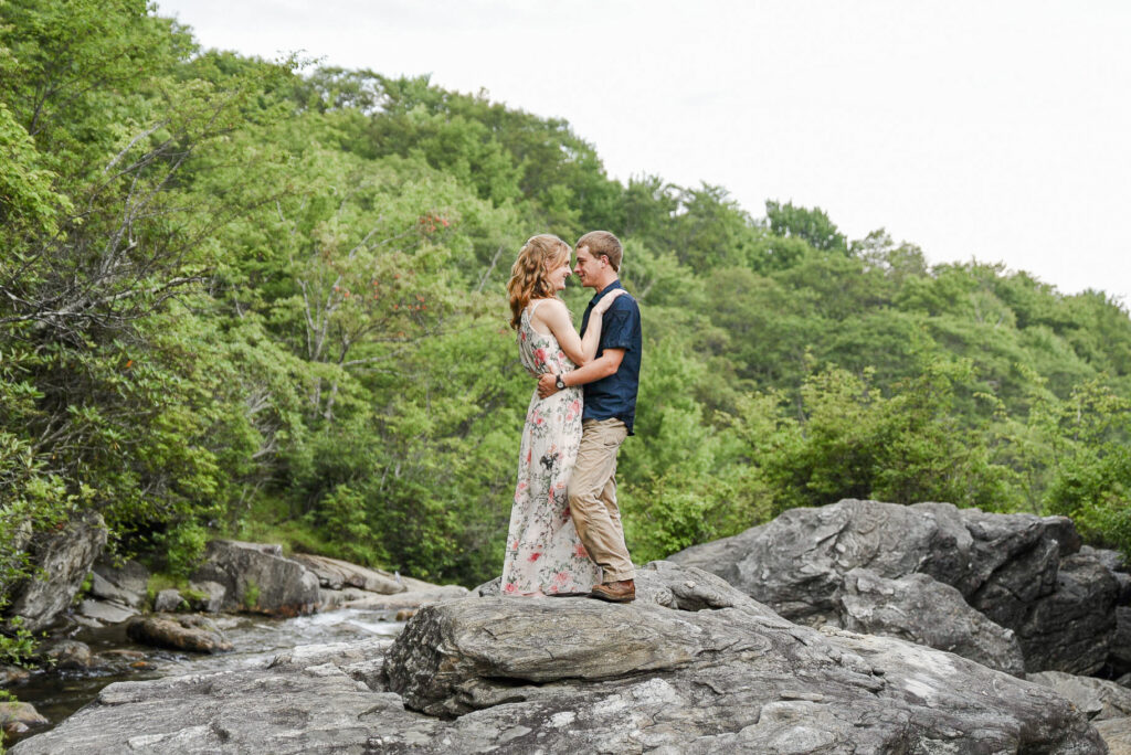 wide image of couple standing on a rock in the middle of grave yard fields