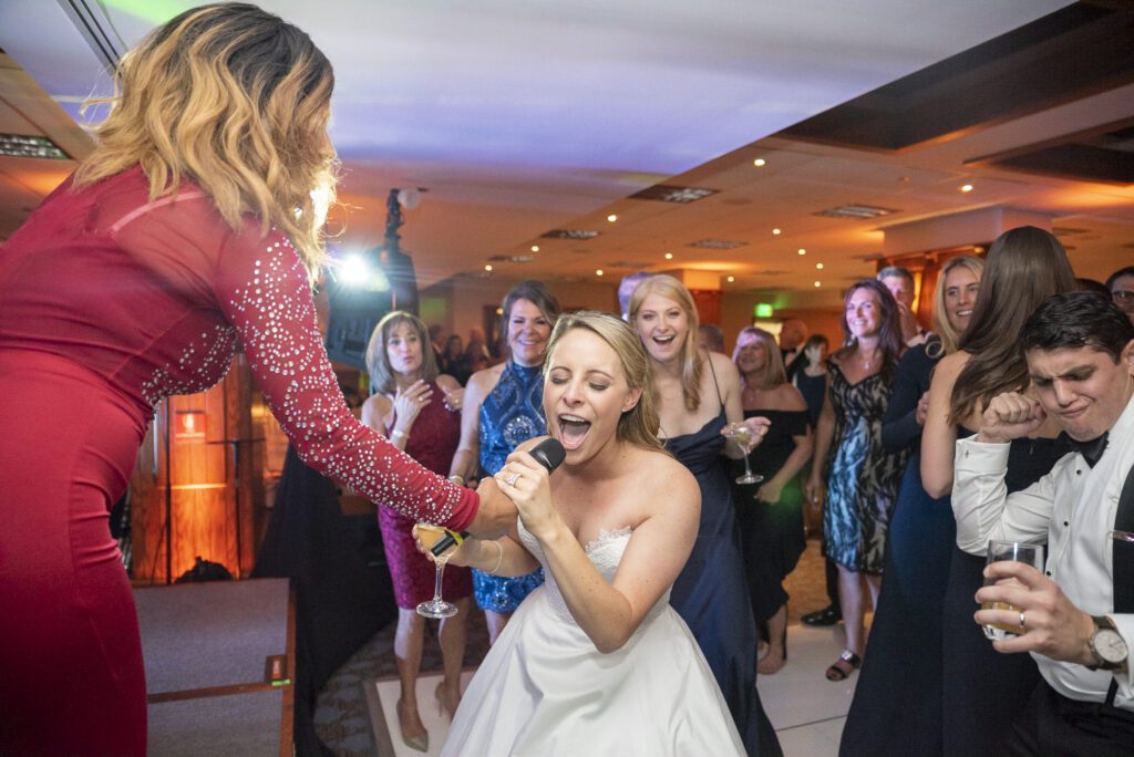 bride singing into microphone during wedding reception at grove park inn Skyline Room