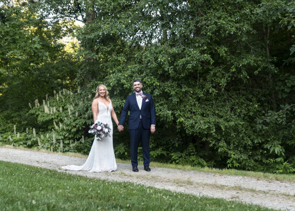 bride and groom walking down path at NC Arboretum