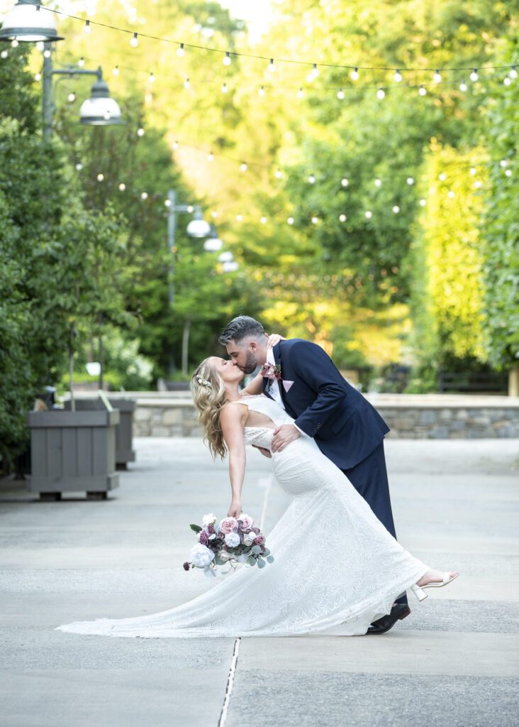 wedding couple at NC Arboretum groom dipping bride for a kiss