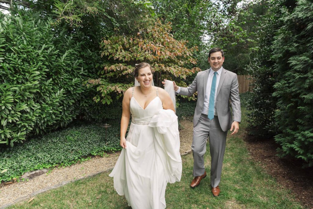 bride and groom holding hands walking outside after first look