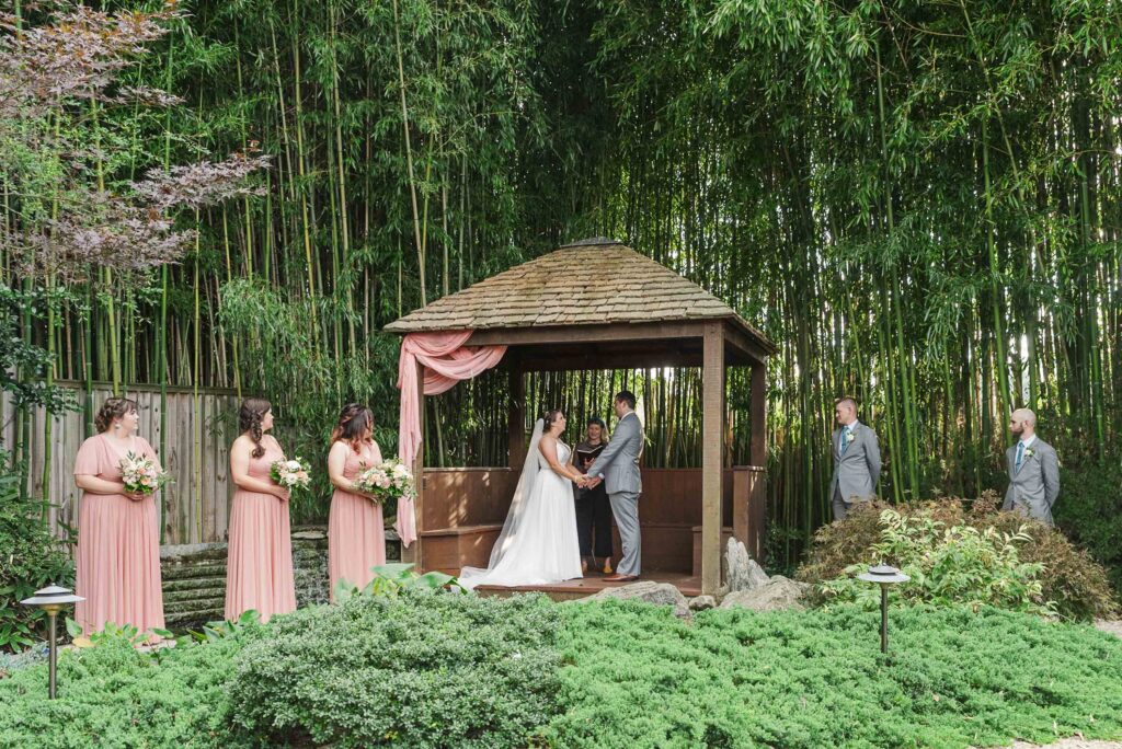 bride and groom standing at altar with bridesmaids and groomsmen during ceremony at Weaver House wedding venue