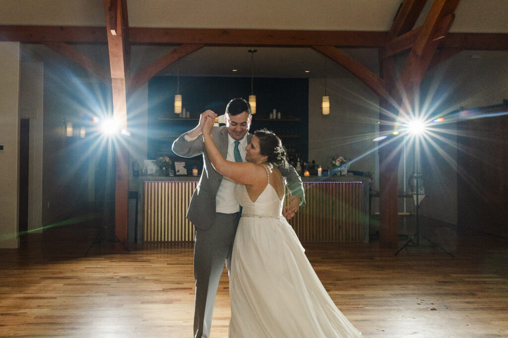 wide of bride and groom last dance with flashing lights in the back at Weaver House wedding venue