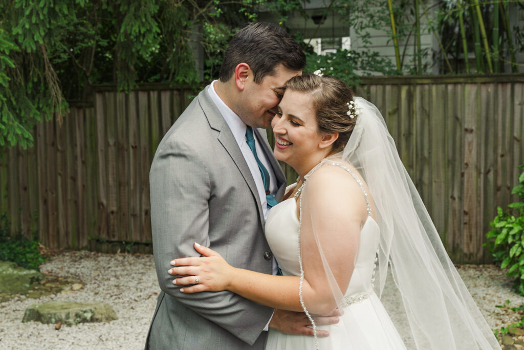 close up portrait of bride and groom embracing and smiling at each other
