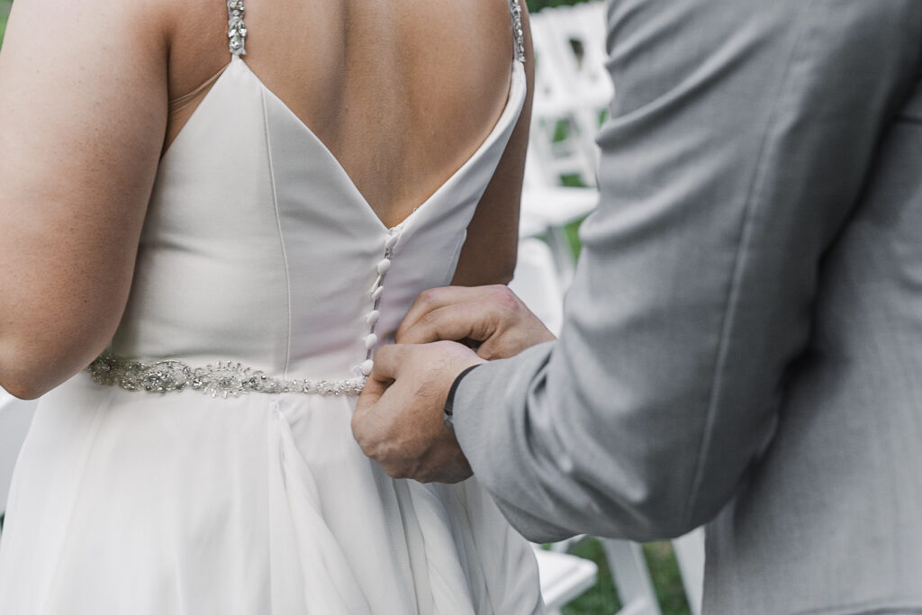 close up detail of groom bustling bride's dress
