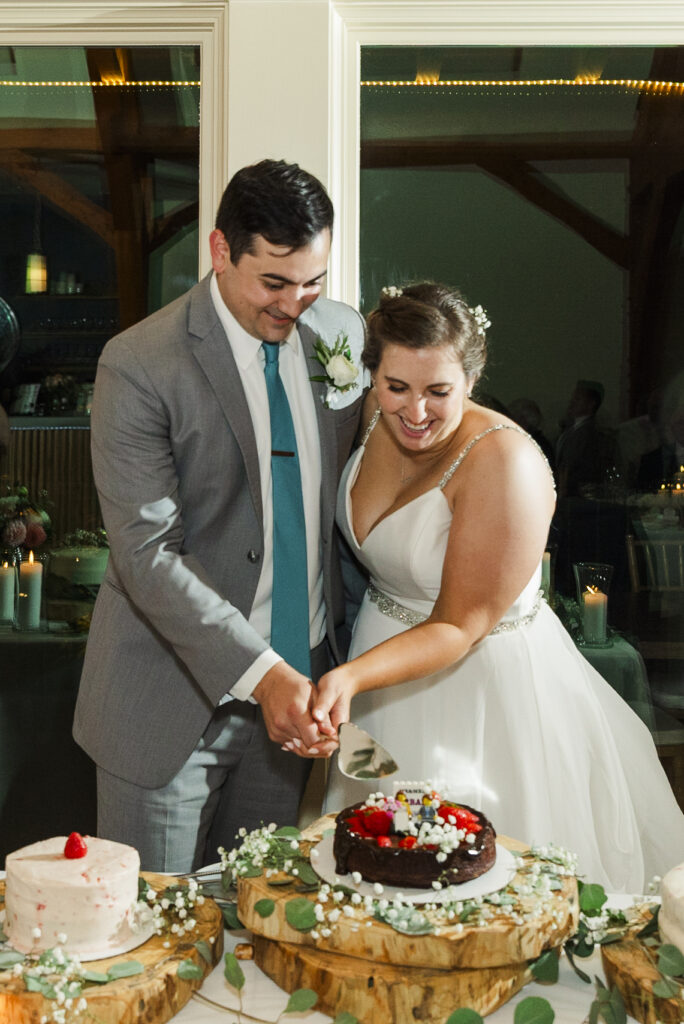 bride and groom holding the knide together cutting the cake