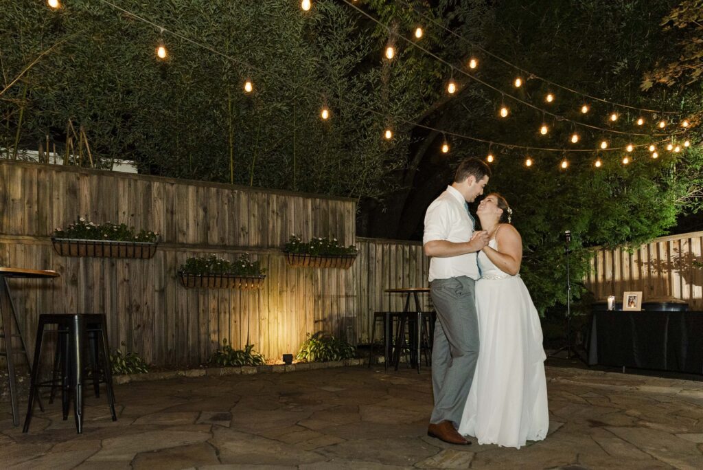 bride and groom having a private dance outside under twinkle lights at Weaver House wedding venue