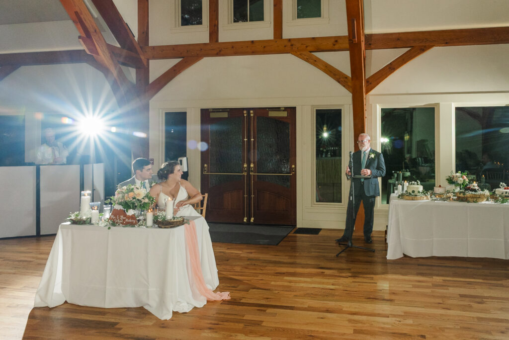 wide of father of the bride giving toast and with bride and groom looking on at Weaver House wedding venue