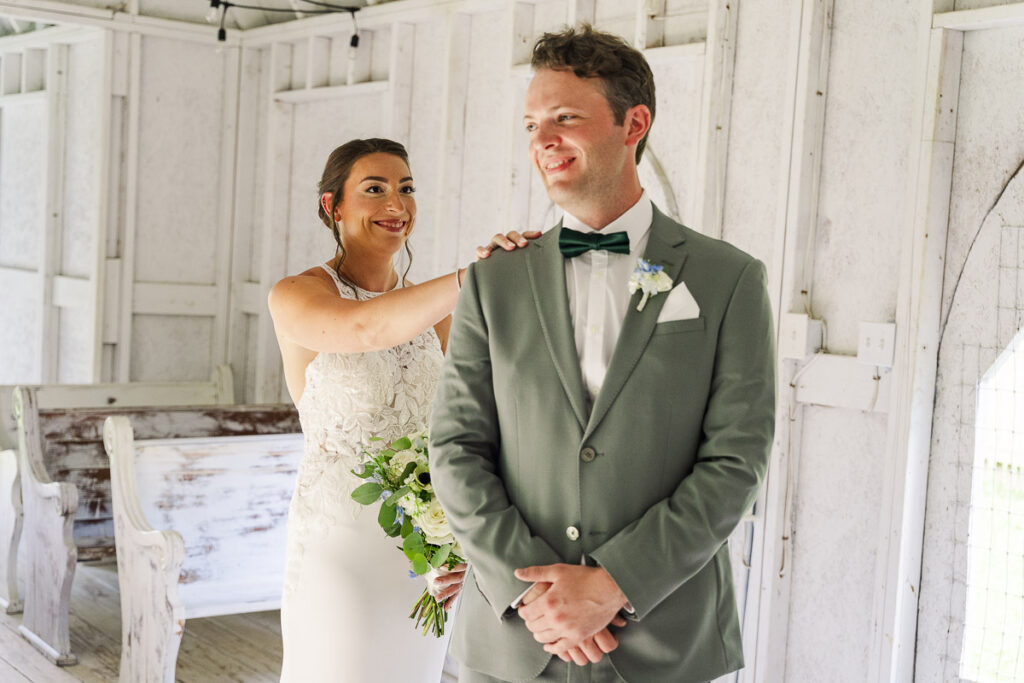 groom turning to see bride during first look in chicken chapel at The Farm A Gathering Place Asheville Candler Wedding Venue