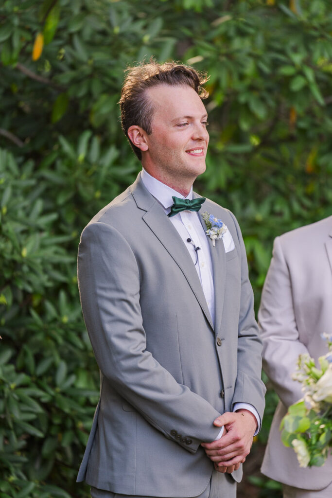 groom smiling as he sees bride walk down the asile