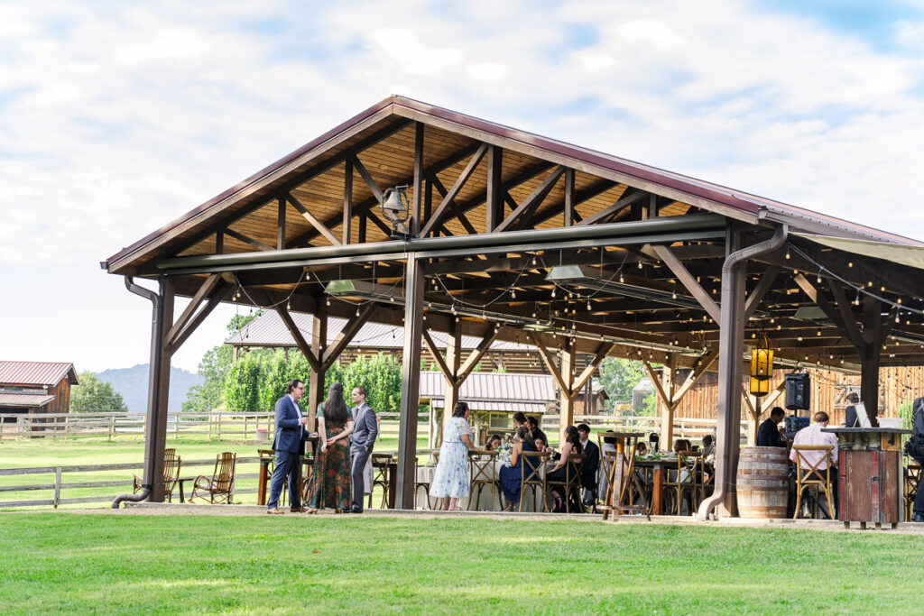 wide of guests under reception shelter at The Farm A Gathering Place Wedding Venue