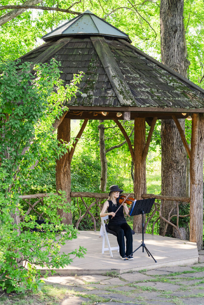 violinist playing during ceremony at The Farm A Gathering Place Wedding Venue
